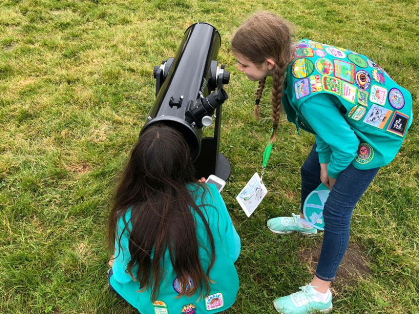 Two Girl Scouts look through a telescope at a star party in the San Francisco Bay area in 2018