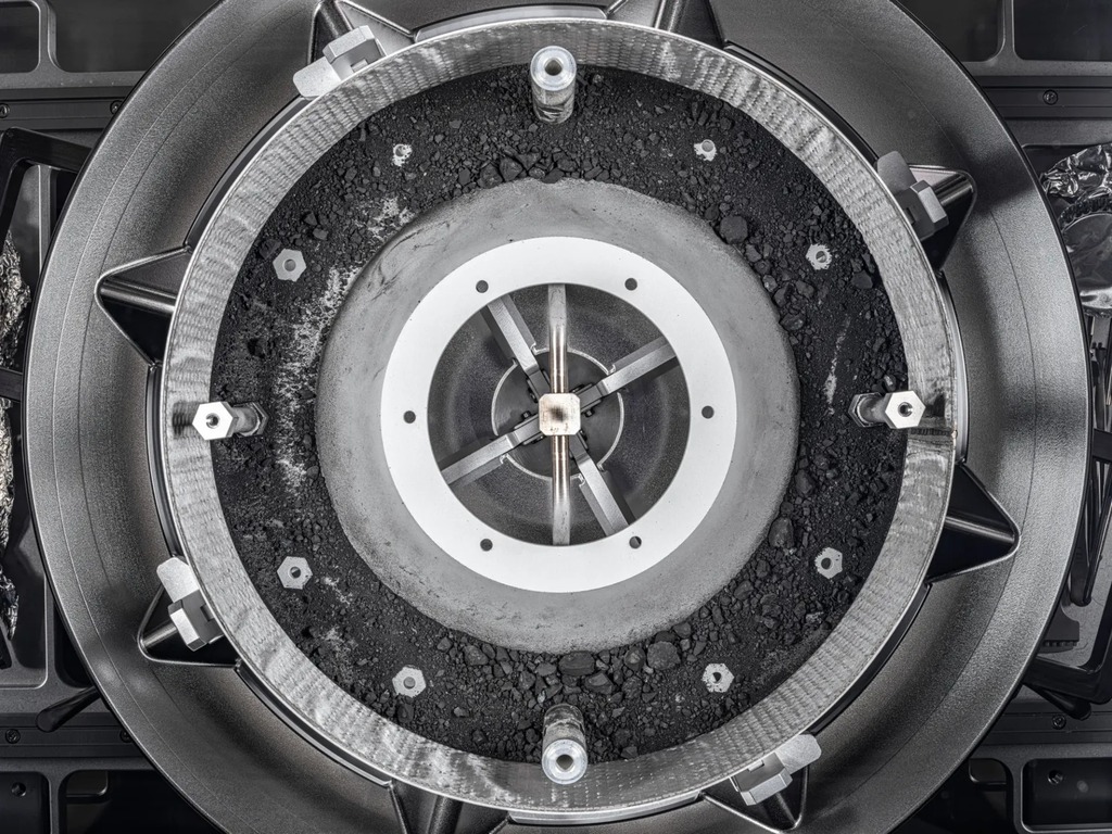 image of the capsule opened revealing gray pieces of rocks and dirt.