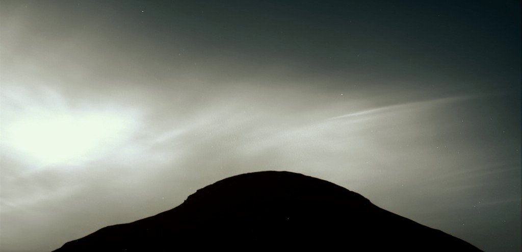Gray image of a black mound under a gray and cloudy sky