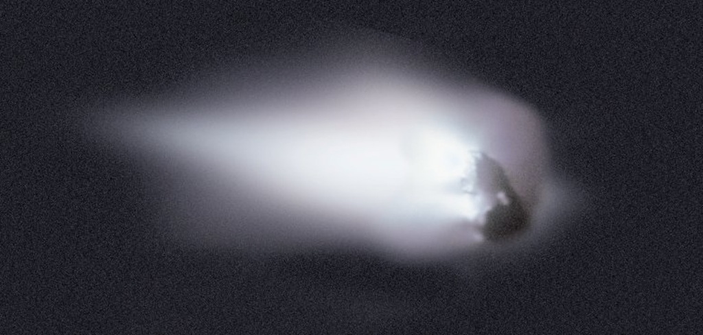 black and white grainy image of the comet in the dark outer space