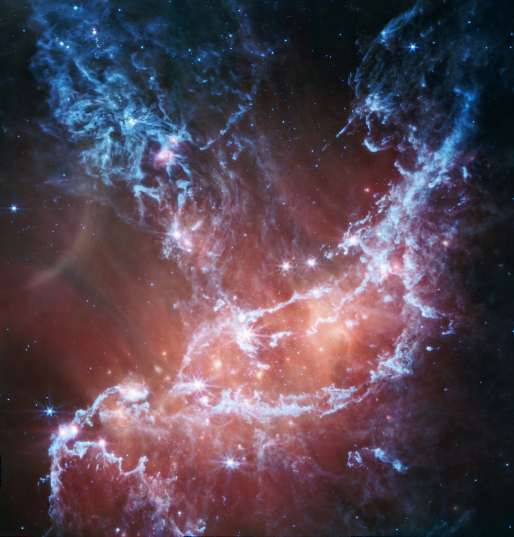 infrared image of NGC 346 emitting beautiful watercolor-like blue and red colors.