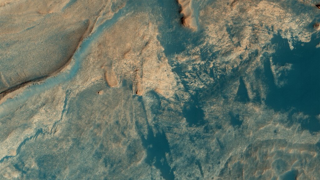 aerial view of Mars with a small bright speck representing the Curiosity Rover