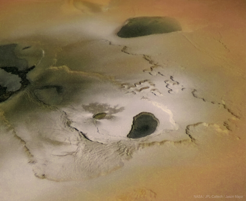 aerial view of a few black spots on Io