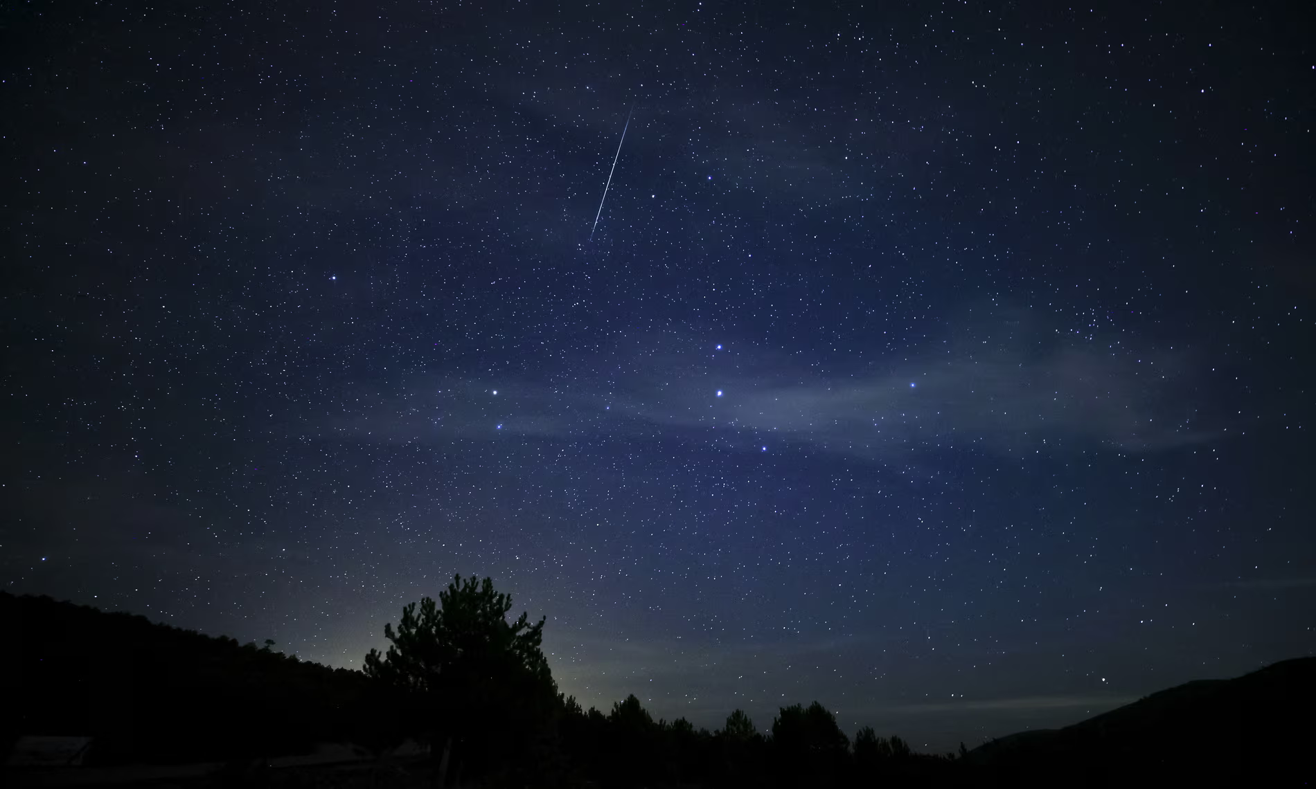 meteor falling from a star filled night sky