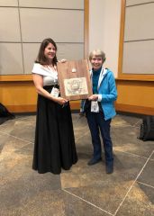 Dr. Janice Bishop being presented her award plaque.